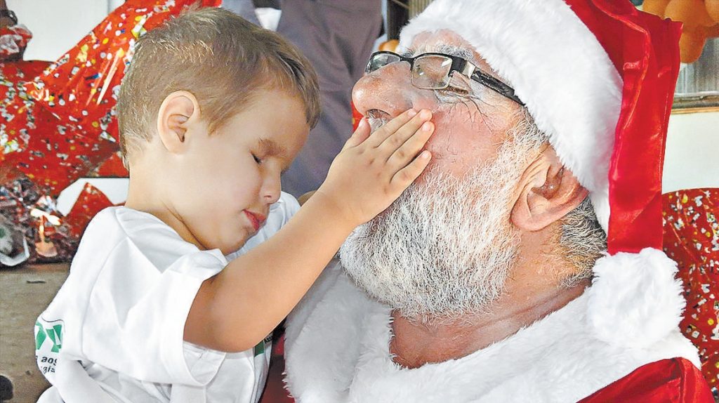 Moisés, de dois anos, dificiente visual, faz carinho no Papai Noel. Foto: Nicole Gil.
