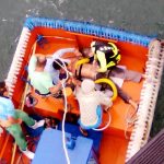 Aliando a técnica de resgate com sling e resgate em altura, o Cb Da Silva adequou uma cadeirinha de rapel e além de aquecer a vítima a vestiu com o equipamento para o transporte até a areia.