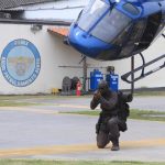 Após desembarcar da aeronave que inicia a sua arrematida, um Tripulante Operacional (TO) completamente equipado assume posição padrão de segurança com seu fuzil em punho. (Foto: Alessandro Reis)