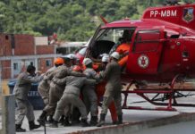 Helicóptero do Corpo de Bombeiros resgata vítima no topo de prédio na Muzema, RJ