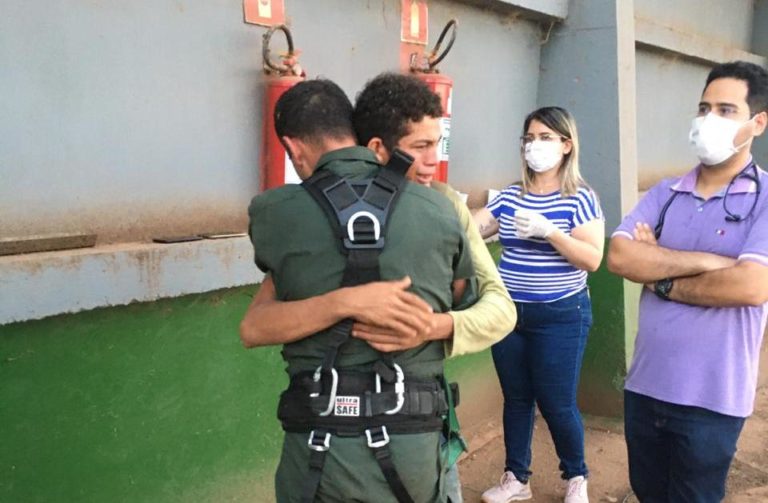 Jovem abraça emocionado tripulante do CIOPAER depois de ser resgatado em silo de soja, em Nova Maringá