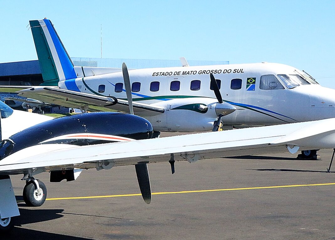 A menina no colo da mãe, com militares do grupamento aéreo da Casa Civil do governo de MS — Foto: Edemir Rodrigues.